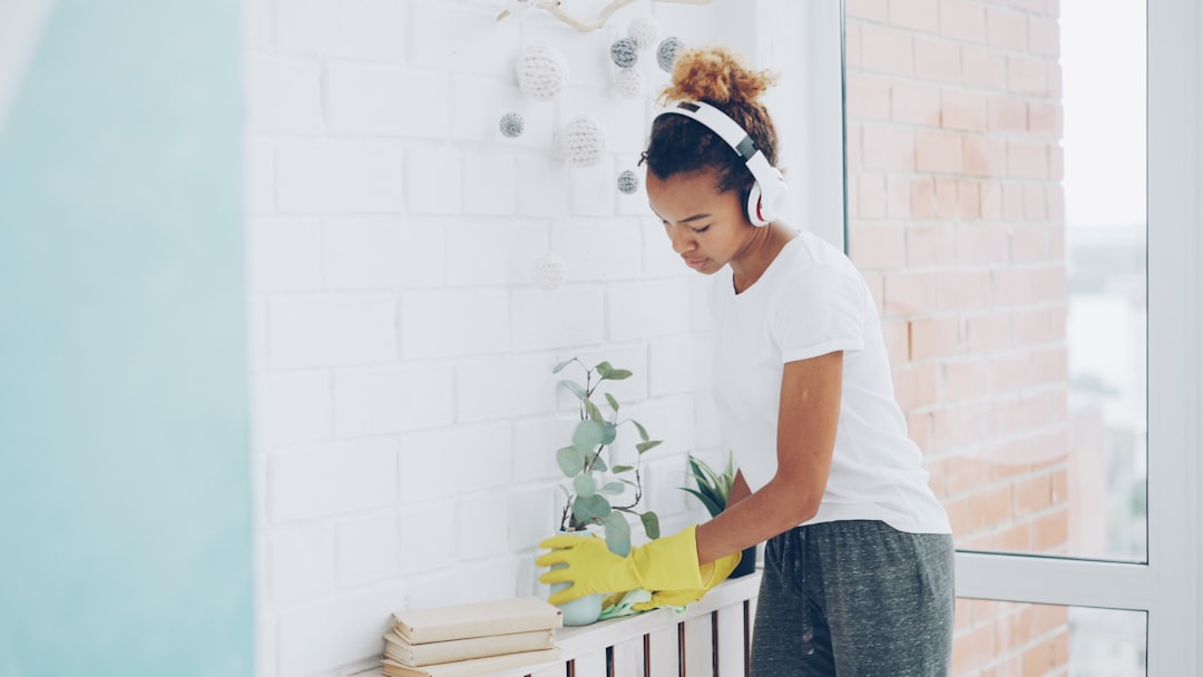 support animal damage. Woman wearing headphones cleans near a window.