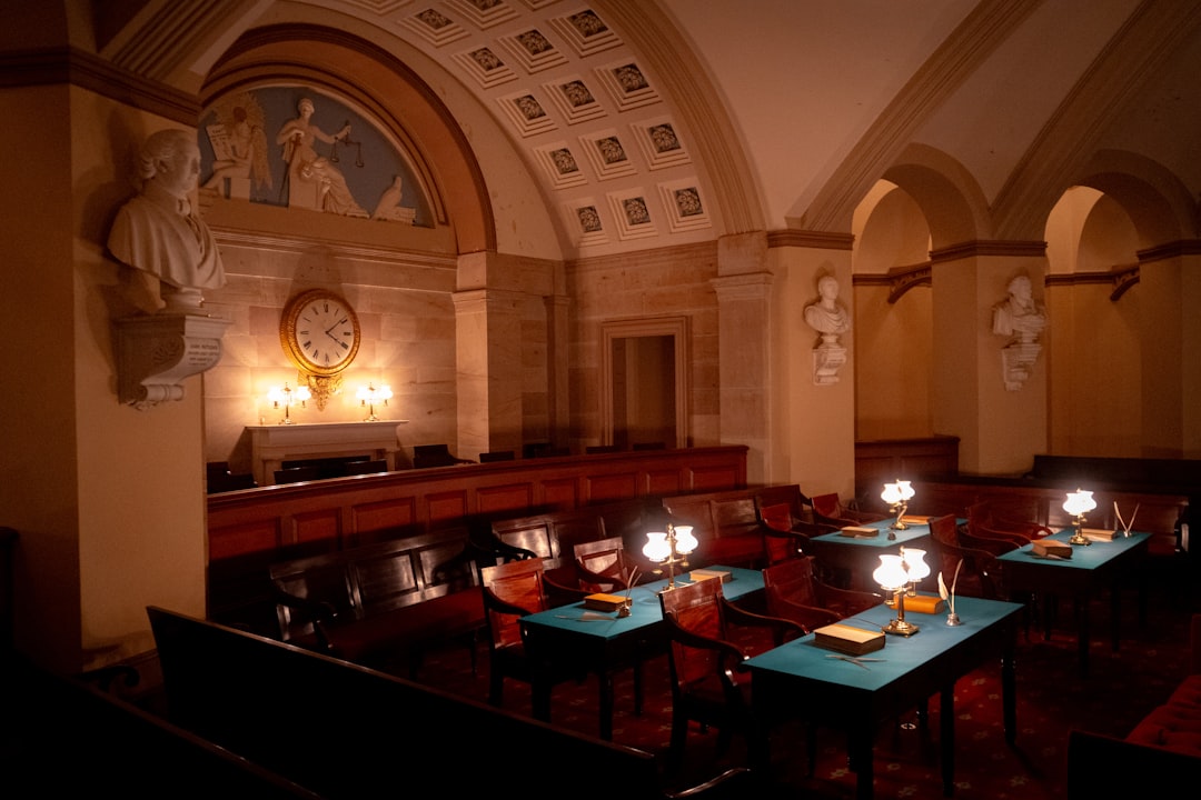 FHA disability definition — A historic courtroom with wooden benches, desks with lamps, and marble busts