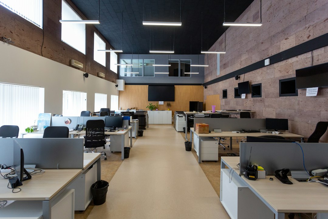 hotel service dog — An open plan office with rows of desks and computers under linear lights