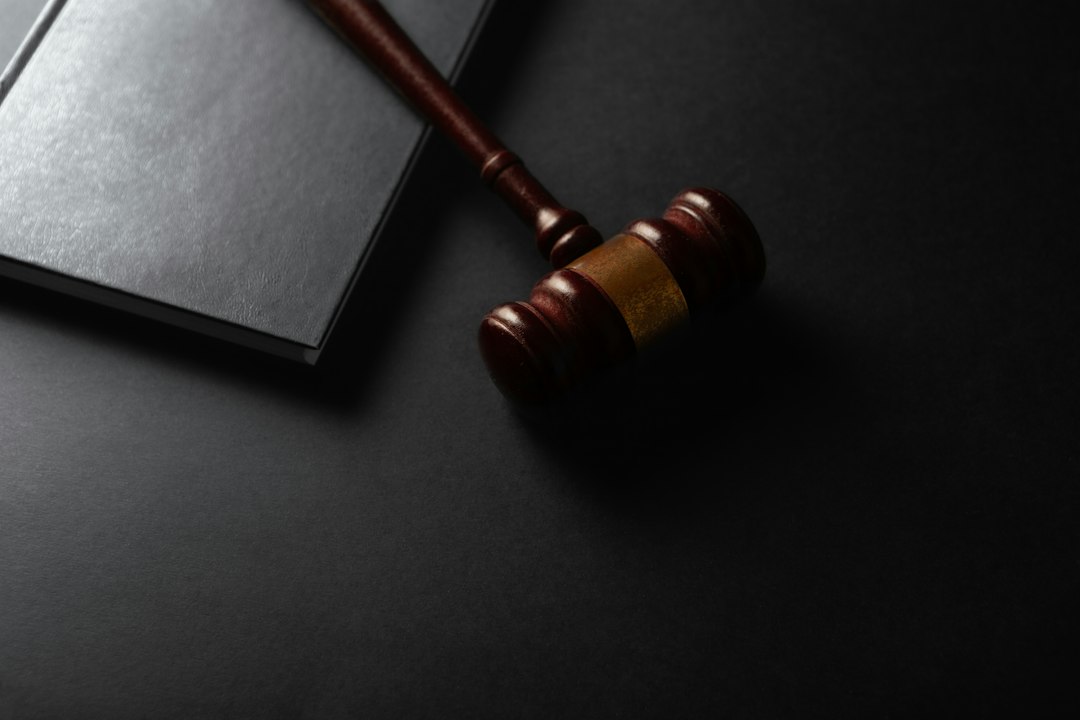support animal liability insurance — Wooden gavel resting on a dark surface next to book